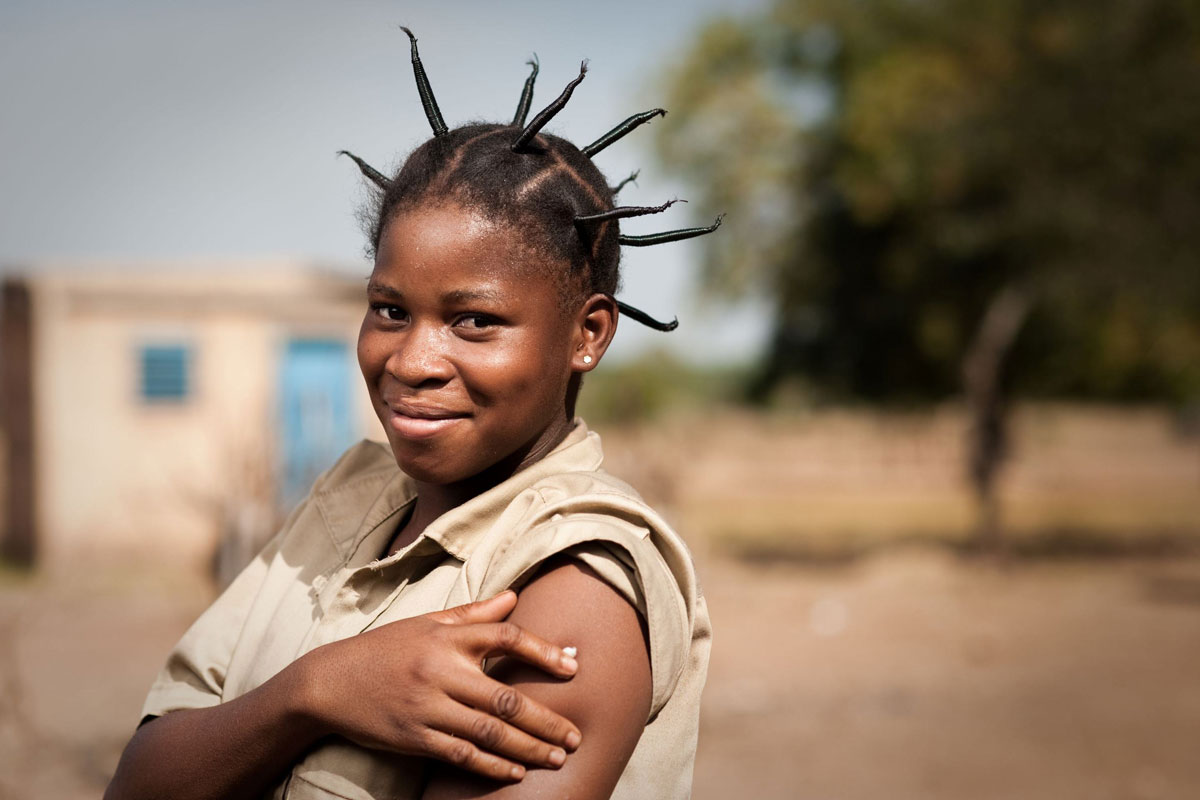 A young woman smiles after receiving a meningitis vaccine. Photo: PATH/Gabe Bienczycki.
