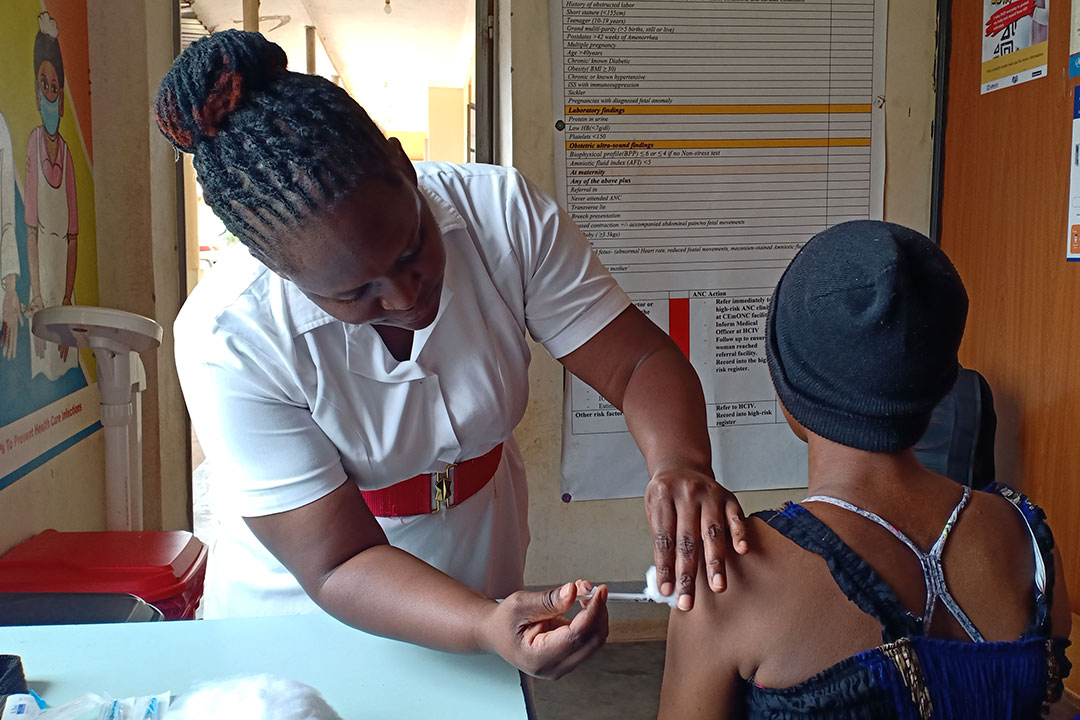 Midwife Betty Nakazibwe gives an expecting mother a tetanus shot. Credit: John Musenze