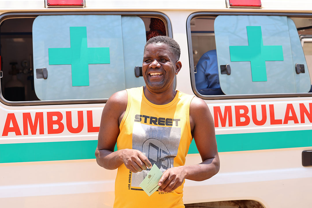 Educator Mphatso Chimangeni poses in front of an ambulance during a visit to Chirimba. Credit: Malawi ministry of health