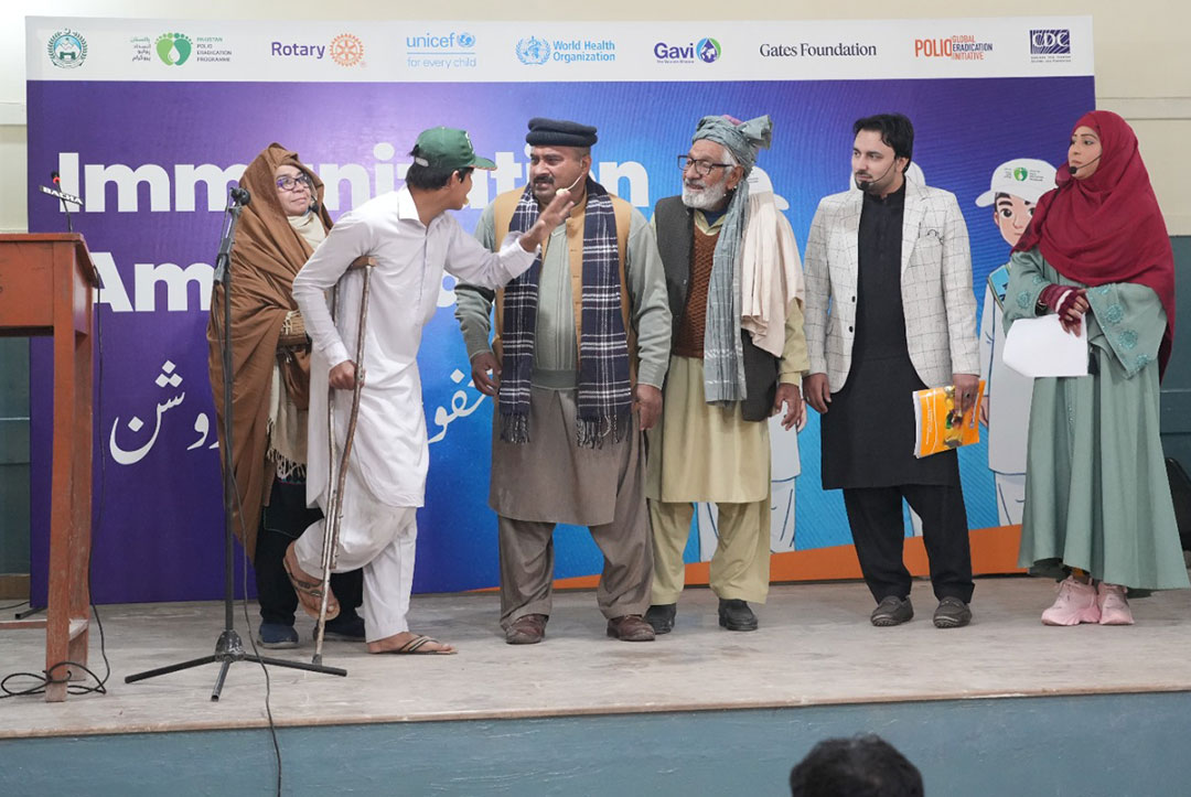 Leaning on crutches, Hassan Munir, a young actor portraying a polio victim in a theatre performance about the importance of childhood vaccination, pleads with Khan Lala, a staunch opponent of immunisation. Credit: Emergency Operation Centre