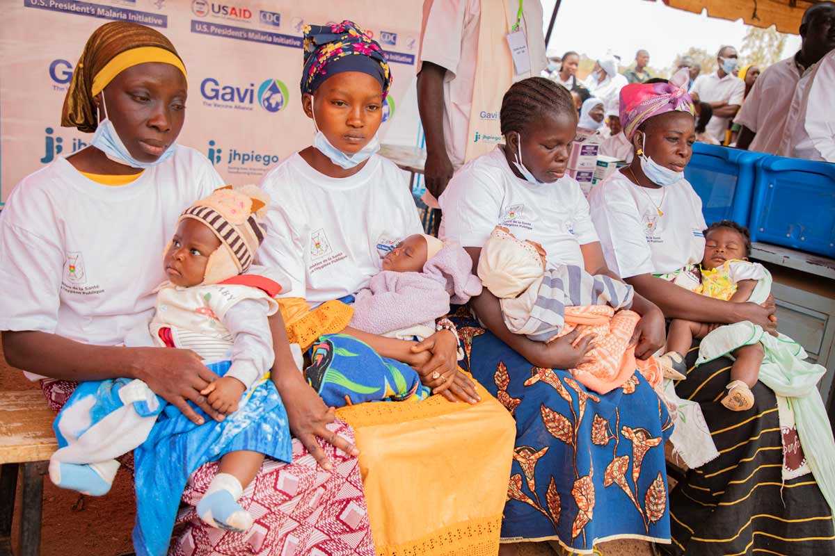 Mothers sit with their children during a malaria vaccination session in Burkina Faso. Credit: Gavi/2024/Arnauld Yalgwueogo