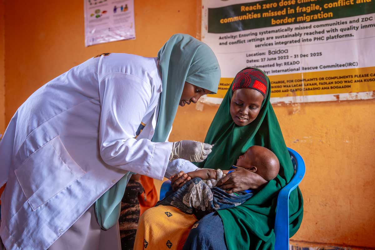 A female health worker administering a vaccine to a child as he is held by his mother in Somalia, during the Reach Zero Dose Children (ZDC) campaign. Credit: Gavi/2024/Mohamed Abdihakim Ali.