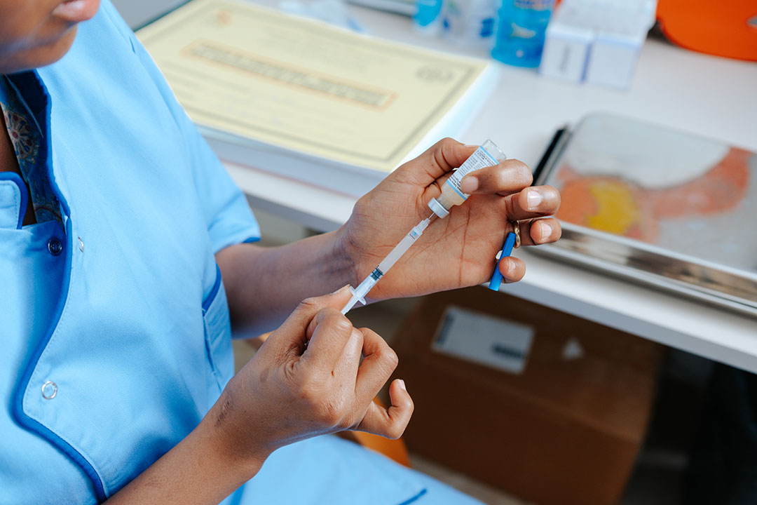 Health care professional prepares vaccine. Gavi/2025/Ollivier Girard