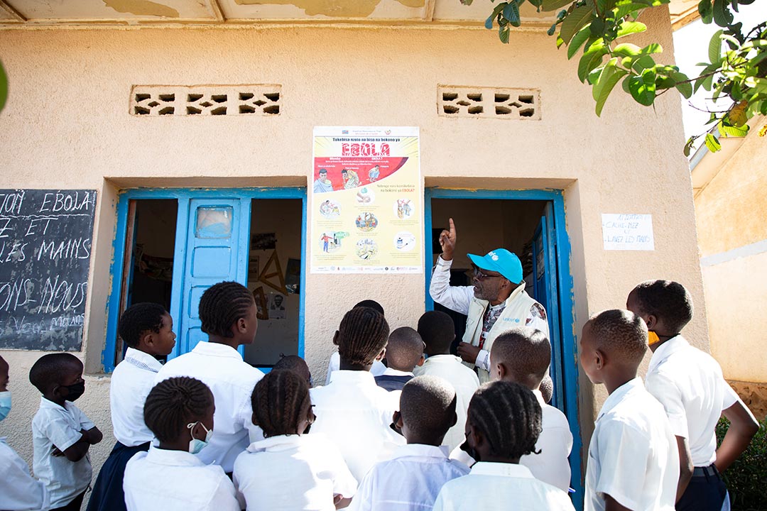 UNICEF WASH Officer Ciza Nyalundja explains Ebola prevention measures to pupils at Epo‑Ville Primary School in Bunia, Ituri Province, DR Congo, on 22 May 2026. © UNICEF/UNI997637/Carmel Ndomb