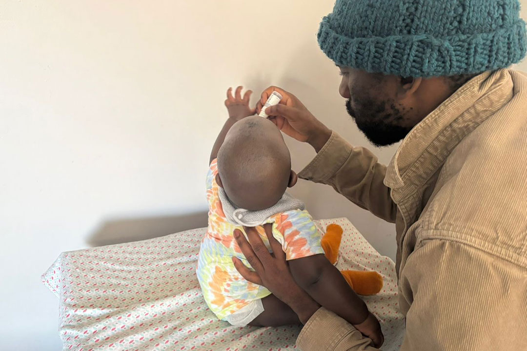 Vusi Simelane gives his child the oral rotavirus vaccine. Credit: Zimkithe Mbulawa
