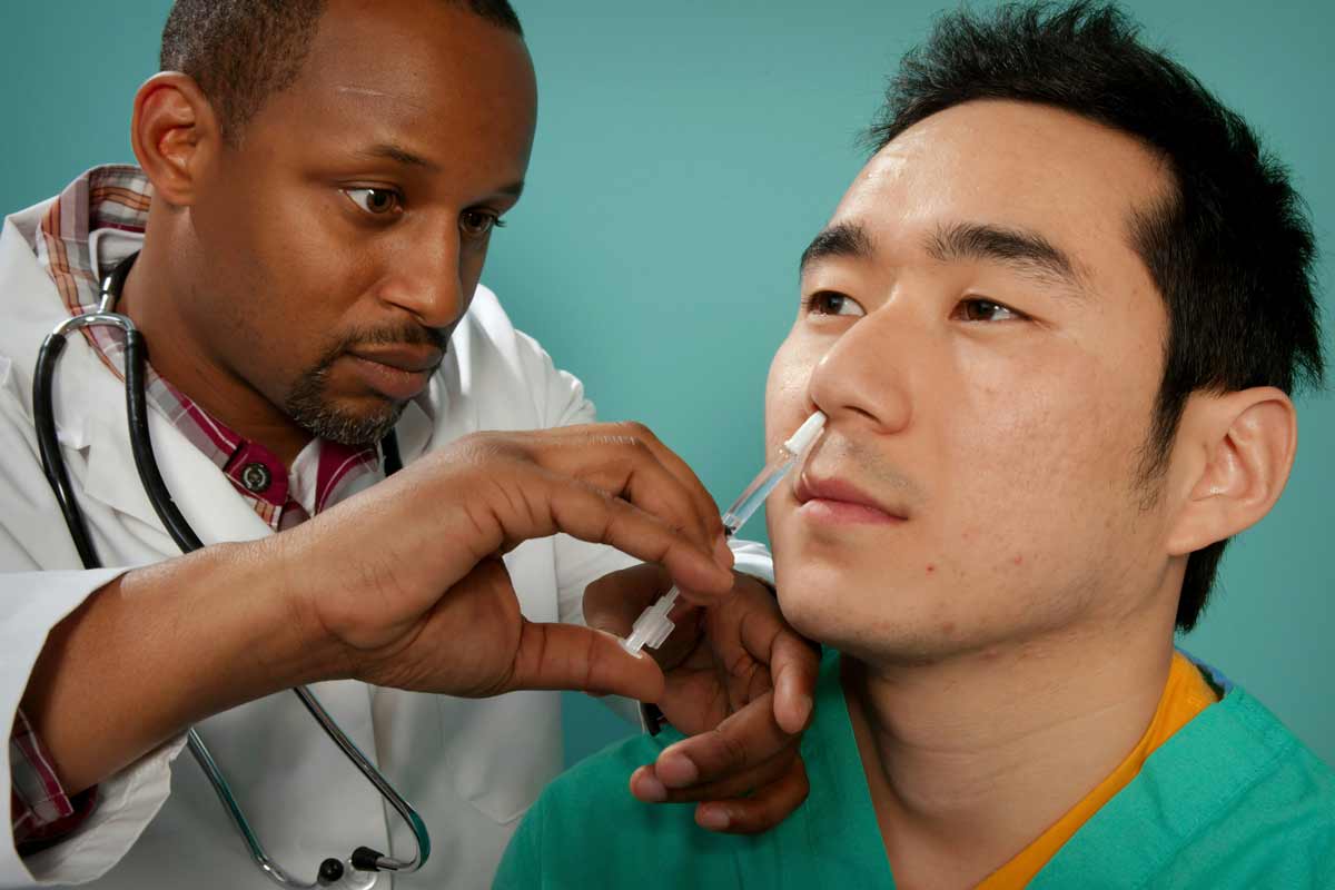 A healthcare practitioner administering a nasal spray vaccine. Credit: CDC