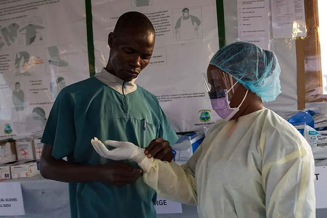 Health personnel dressing up in personal protective equipment (PPE) during a 2015 Ebola outbreak in Liberia. The 2014-16 West Africa Ebola epidemic catalysed a wave of investment in Africa’s response capacity. Copyright: UNMEER (CC BY-ND 2.0)