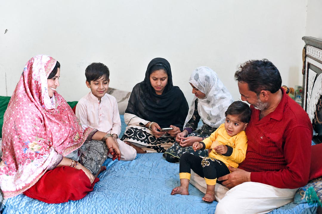 Siraj Ahmed, his wife Humaira, and four of their five children at home. Credit: REEDS, Pakistan