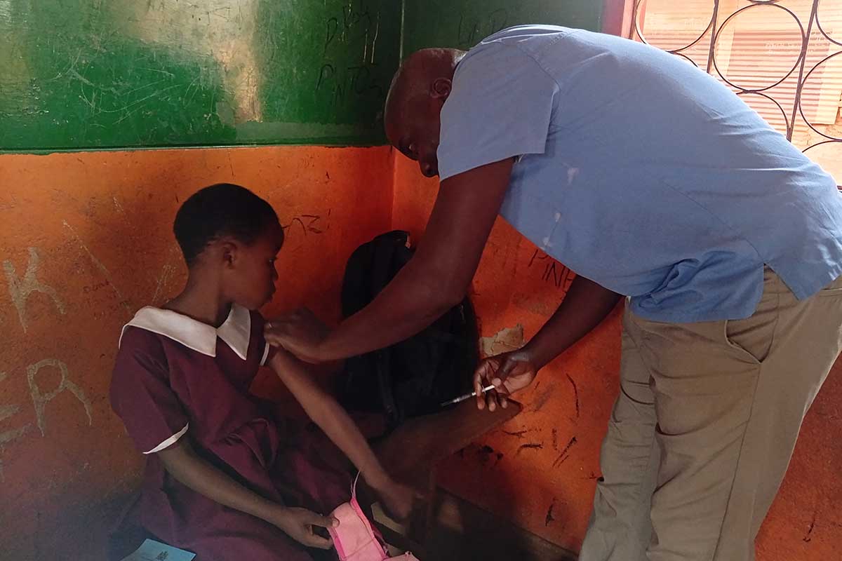 Alick Phiri, a Health Surveillance Assistant, administers vaccine to a student in Blantyre, Malawi. Credit: Josephine Chinele
