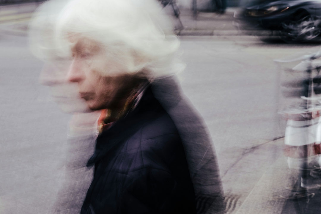 Elderly woman walking in the street. Photo by Mario Heller on Unsplash