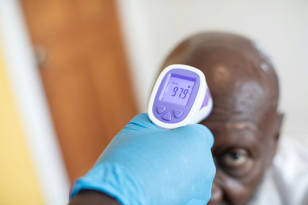 A nurse takes the temperature of a patient. Photo by Nappy on Unsplash