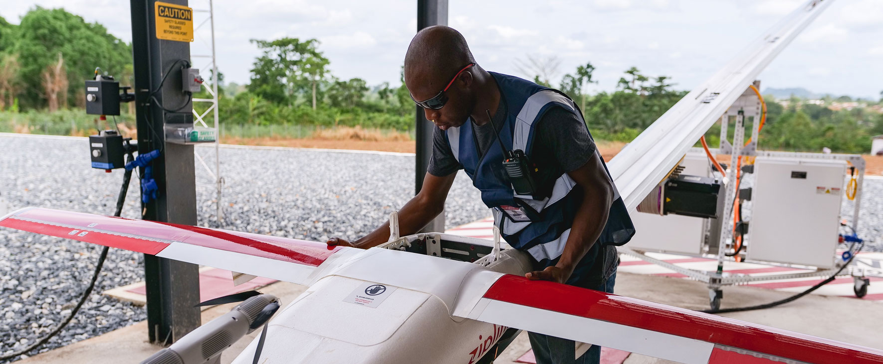 A drone technician prepares a drone for delivering vaccines
