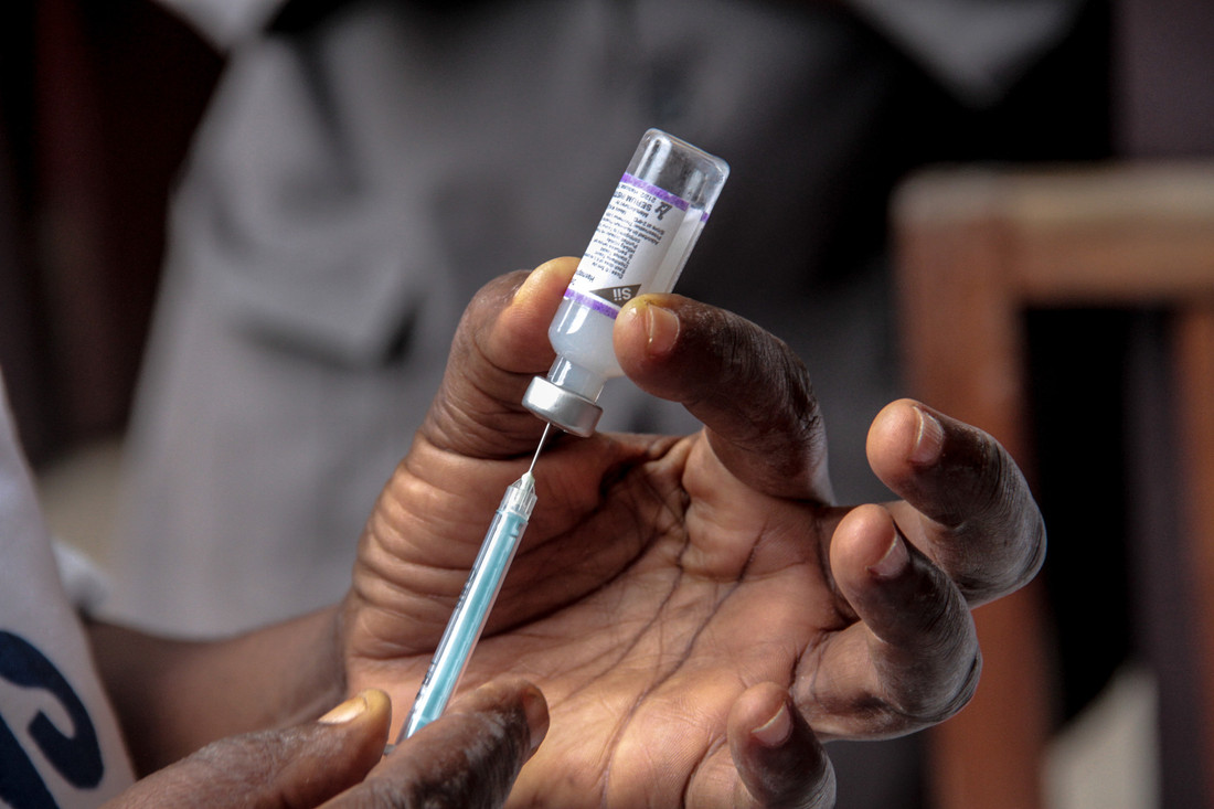 A vaccine syringe drawing a vaccine from a vial