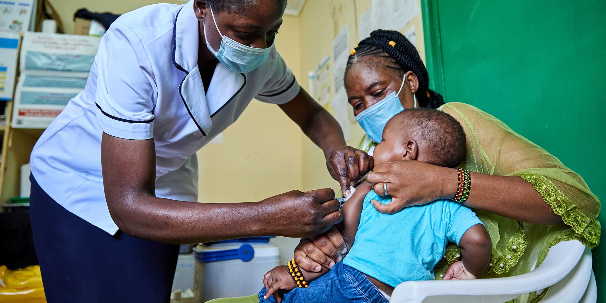 Nurse Janet Wanyama vaccinates 9-month-old Brilliant Hope against malaria while his mother Juliah Machanja watches at the Malava County Hospital Child Welfare Clinic in Kakamega, Kenya. Credit: Gavi/2021/White Rhino Films-Lameck Orina